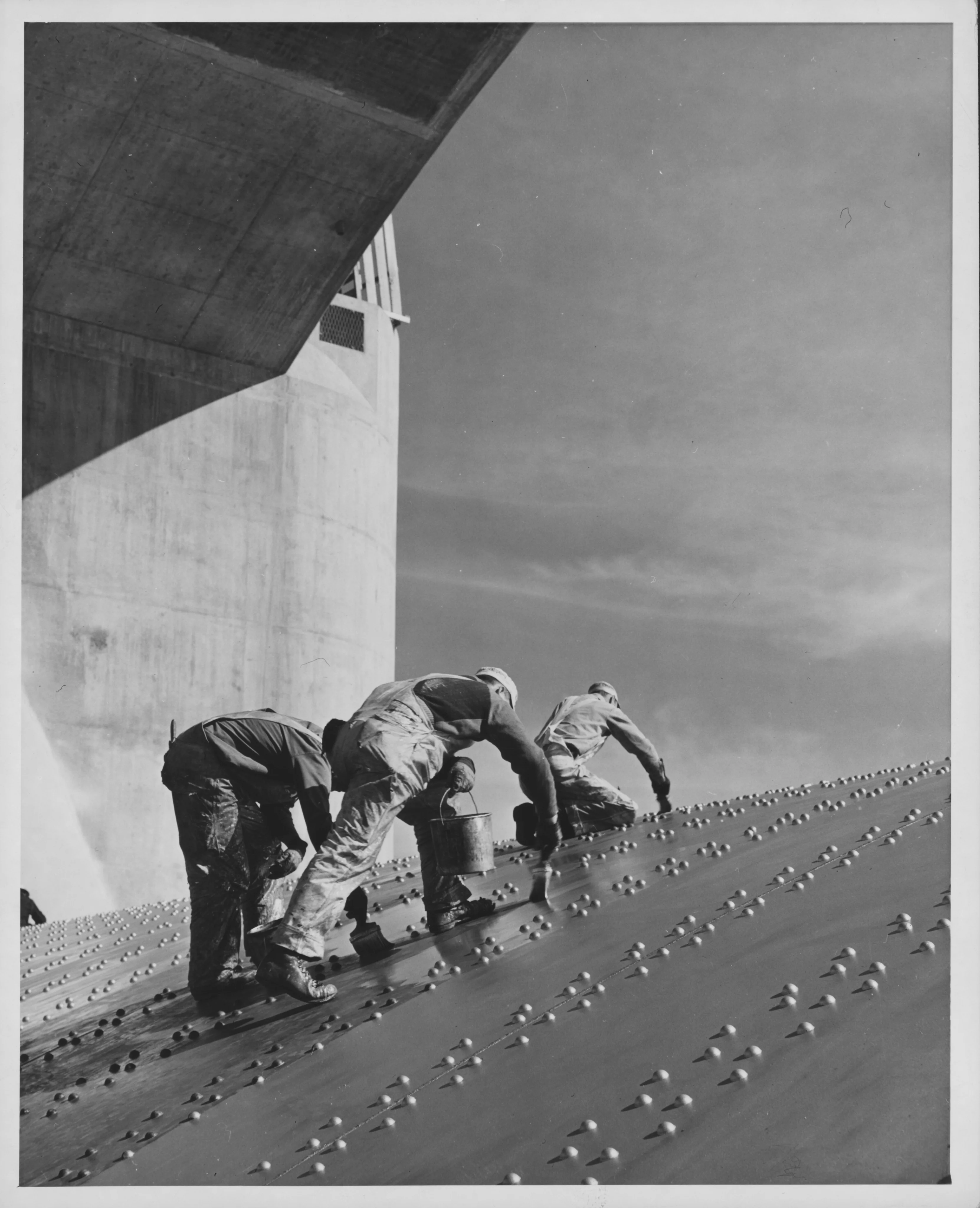 Workers painting Hoover Dam's riveted steel spillway